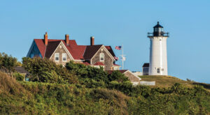 Nobska Light, a lighthouse in Falmouth Massachusetts, with the lightkeeper’s house just peaking out above trees.